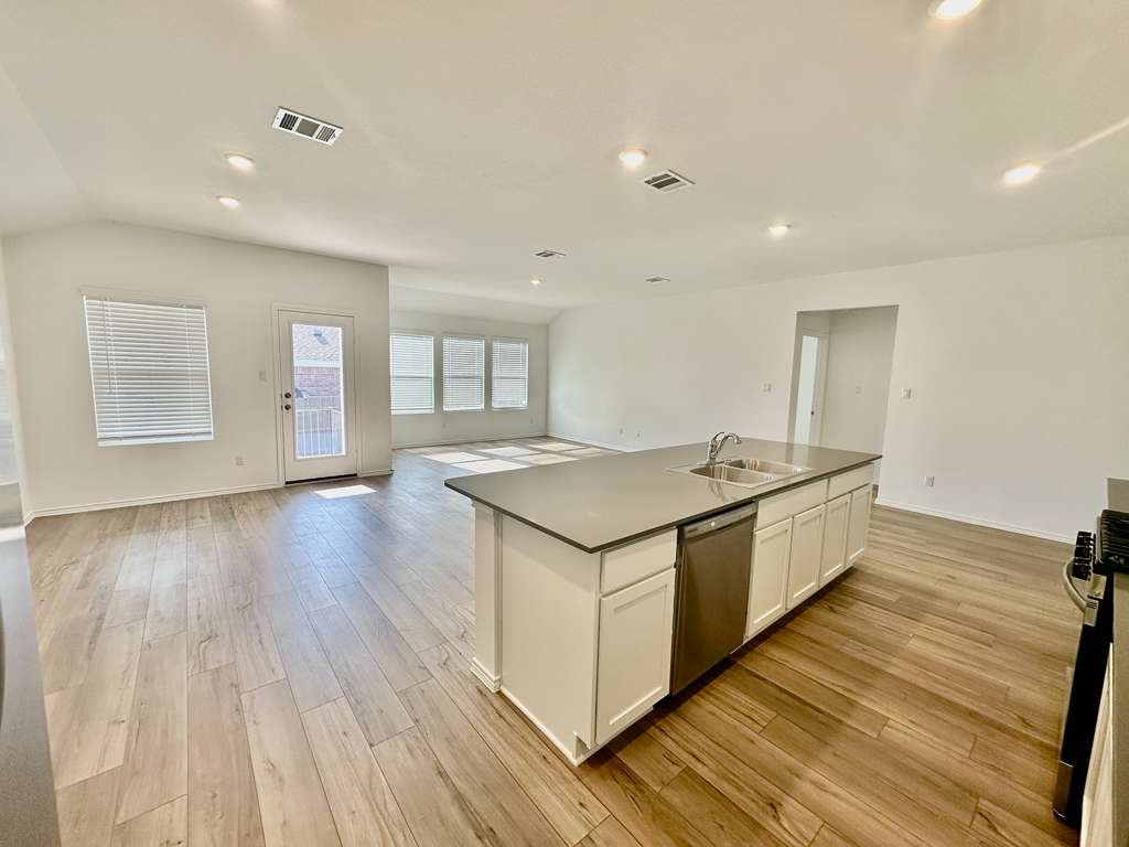 4104 Home Pl Road Georgetown, TX 78628 - Photo 32 of 35 Kitchen with a kitchen island with sink, open floor plan, white cabinetry, range, and stainless steel dishwasher