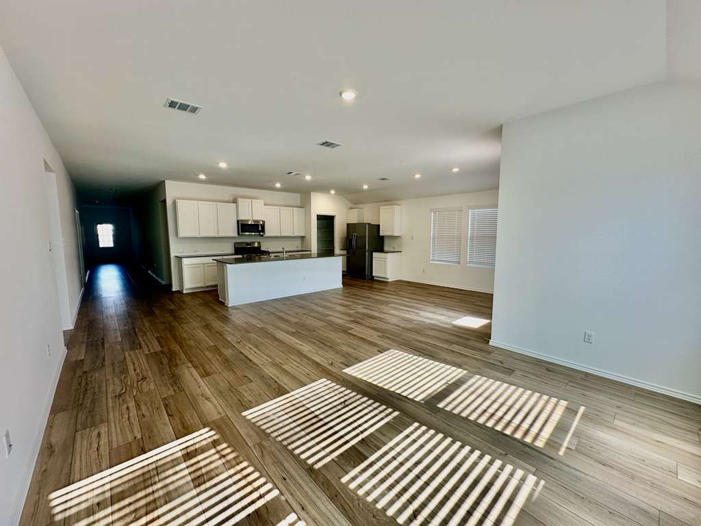 4104 Home Pl Road Georgetown, TX 78628 - Photo 33 of 35 Kitchen featuring open floor plan, white cabinetry, dark wood-style floors, stainless steel appliances, and dark countertops