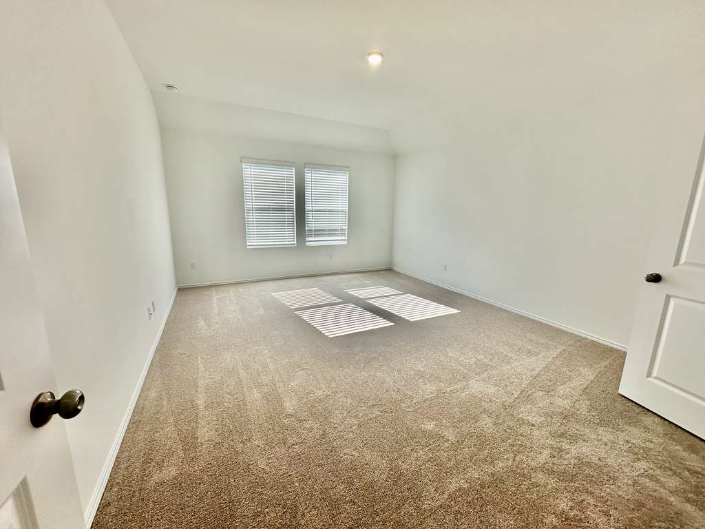 4104 Home Pl Road Georgetown, TX 78628 - Photo 19 of 35 Empty room with light colored carpet and vaulted ceiling