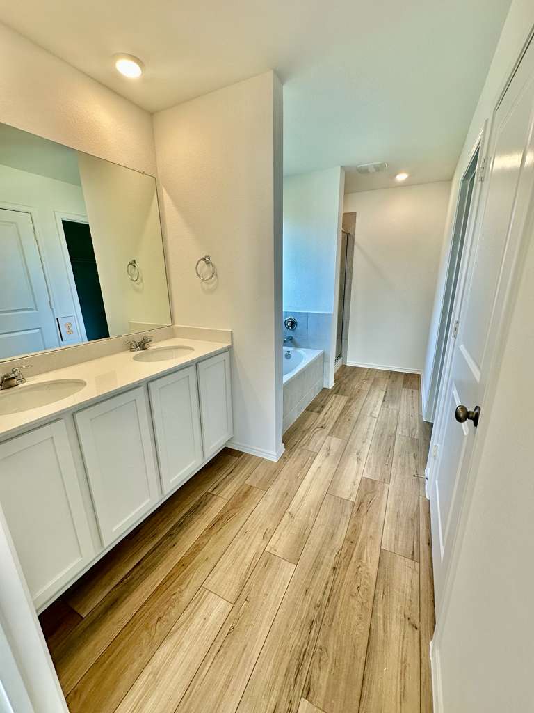 4104 Home Pl Road Georgetown, TX 78628 - Photo 21 of 35 Bathroom featuring double vanity, a garden tub, a shower stall, light wood-type flooring, and recessed lighting