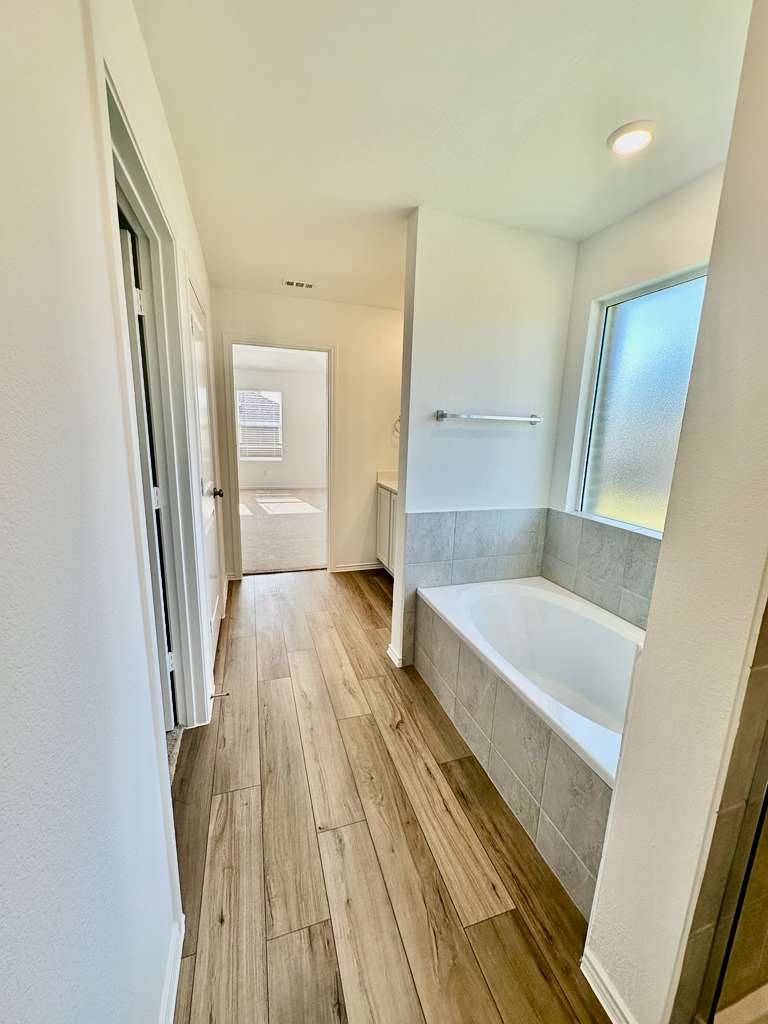 4104 Home Pl Road Georgetown, TX 78628 - Photo 23 of 35 Bathroom with a garden tub, light wood finished floors, and vanity