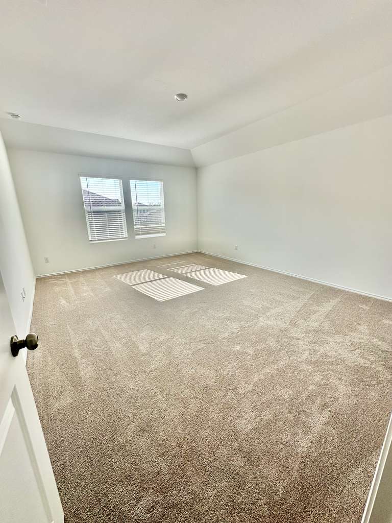 4104 Home Pl Road Georgetown, TX 78628 - Photo 24 of 35 Carpeted empty room featuring baseboards and vaulted ceiling