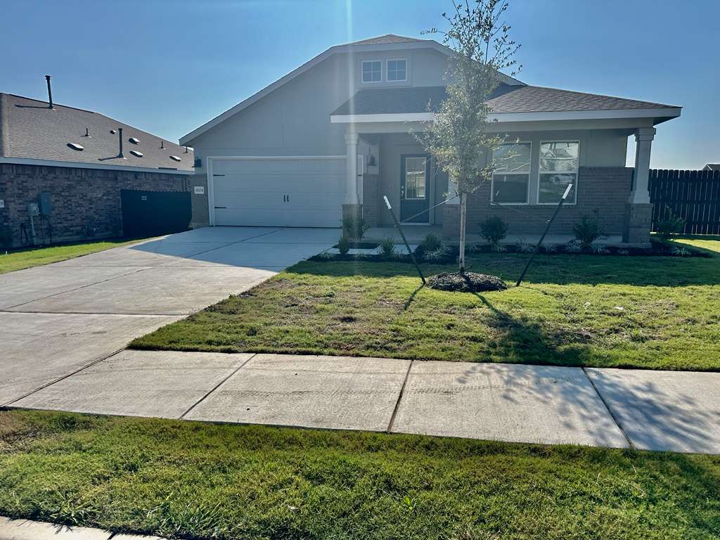 4104 Home Pl Road Georgetown, TX 78628 - Photo 4 of 35 View of front of home featuring concrete driveway, brick siding, a garage, and stucco siding