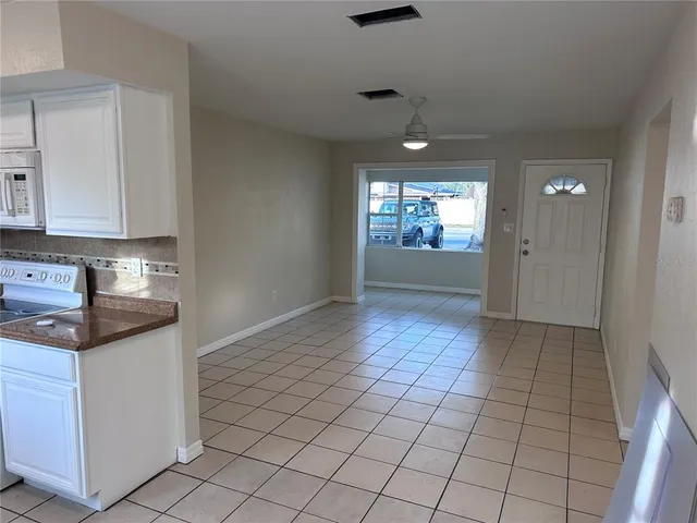 a kitchen with granite countertop white cabinets and window