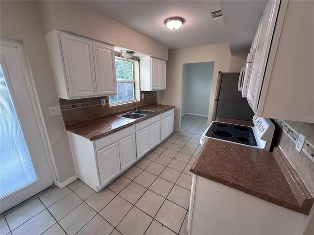 a kitchen with a stove and white cabinets