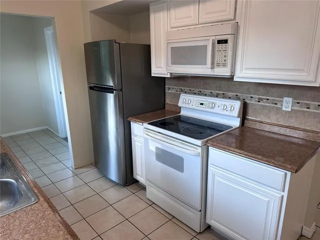 a kitchen with granite countertop a sink stove and refrigerator