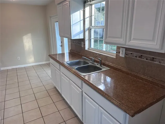 a kitchen with granite countertop a sink a stove and cabinets