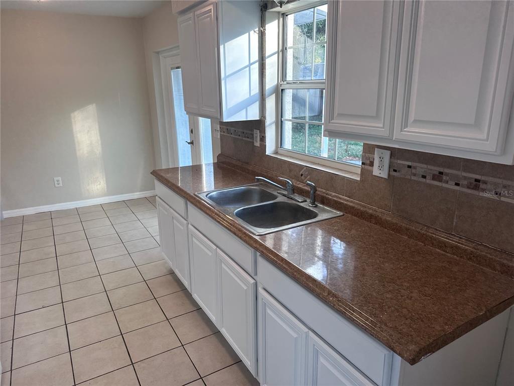 5772 94th Avenue Pinellas Park, FL 33782 - Photo 9 of 29 a kitchen with granite countertop a sink a stove and cabinets