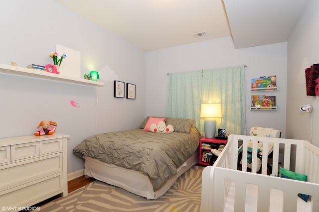 69 East 16th Street, Unit 2 Chicago, IL 60616 - Photo 14 of 16 a bedroom with a bed and wooden floor