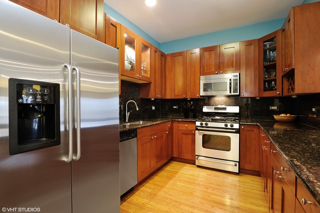 69 East 16th Street, Unit 2 Chicago, IL 60616 - Photo 8 of 16 a kitchen with stainless steel appliances granite countertop a stove a sink and a refrigerator