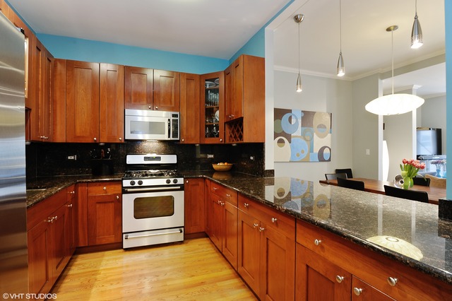 69 East 16th Street, Unit 2 Chicago, IL 60616 - Photo 9 of 16 a kitchen with stainless steel appliances granite countertop a sink a stove and a wooden cabinets