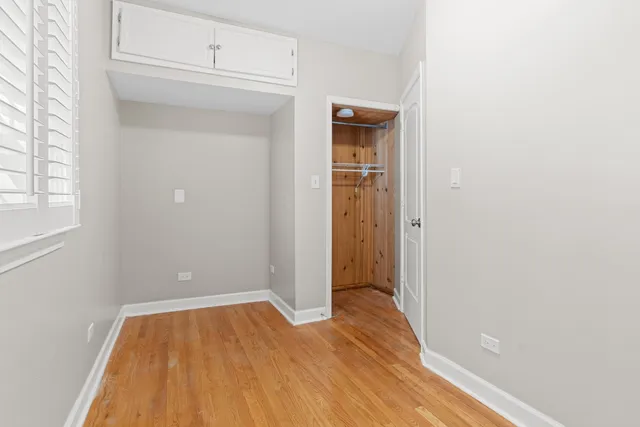 a view of empty room with wooden floor
