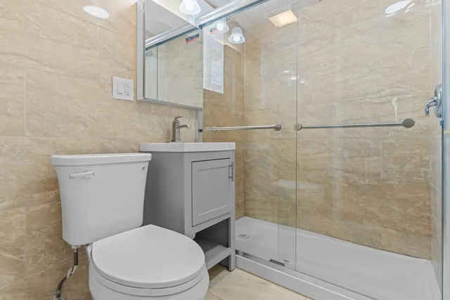 a bathroom with a sink a toilet and shower