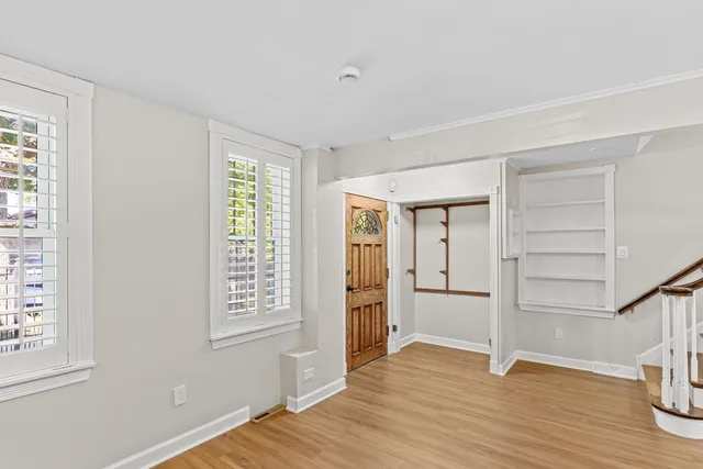 a view of an empty room with closet and a window