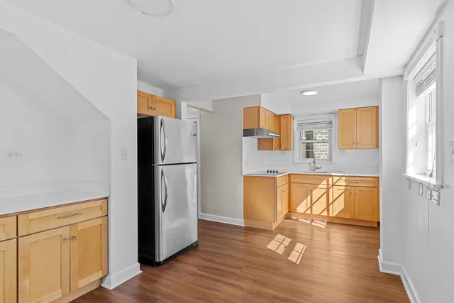 a view of a kitchen with wooden floor and a refrigerator