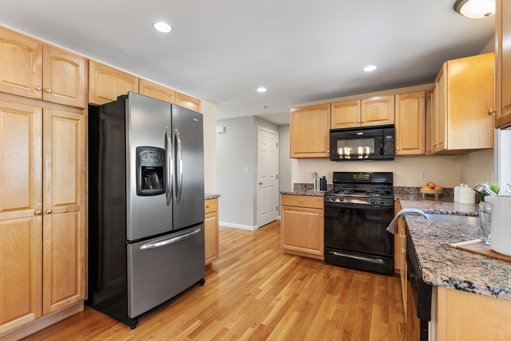 1005 Trapelo Road, Unit 8 Waltham, MA 02452 - Photo 4 of 24 a kitchen with stainless steel appliances granite countertop a refrigerator a stove a sink and a microwave