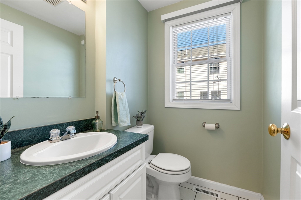 1005 Trapelo Road, Unit 8 Waltham, MA 02452 - Photo 10 of 24 a bathroom with a granite countertop sink vanity mirror and a toilet