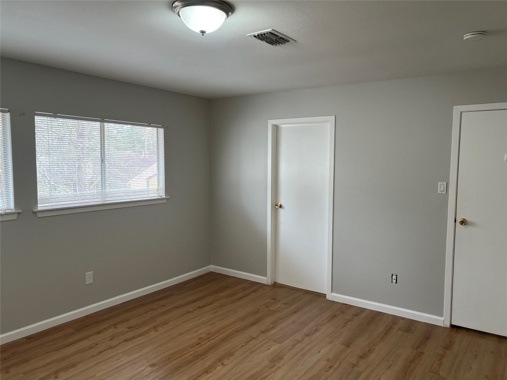 65 Yewleaf Road The Woodlands, TX 77381 - Photo 12 of 21 an empty room with wooden floor and windows