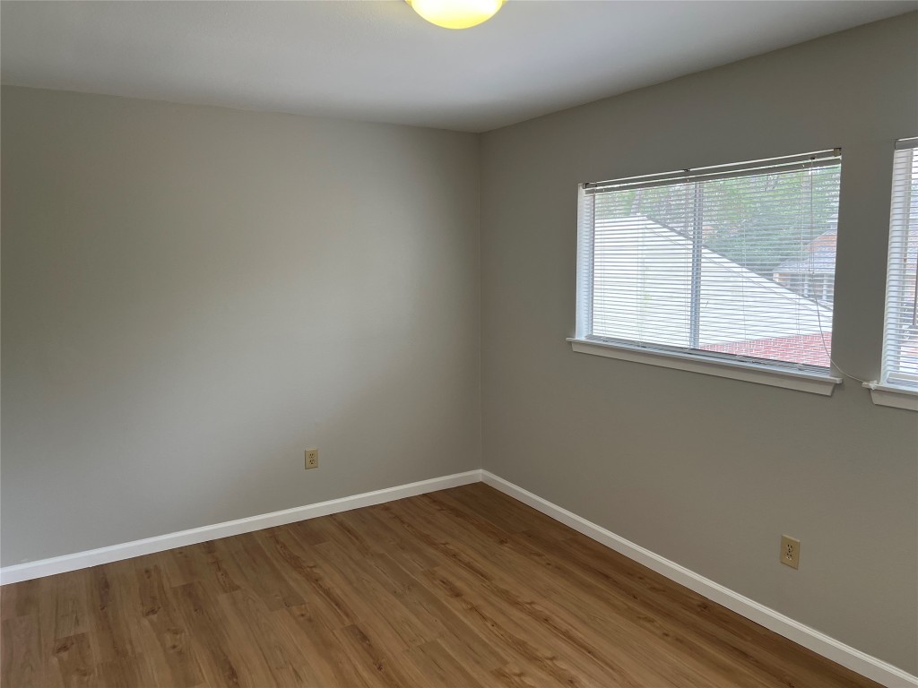 65 Yewleaf Road The Woodlands, TX 77381 - Photo 15 of 21 an empty room with wooden floor and windows
