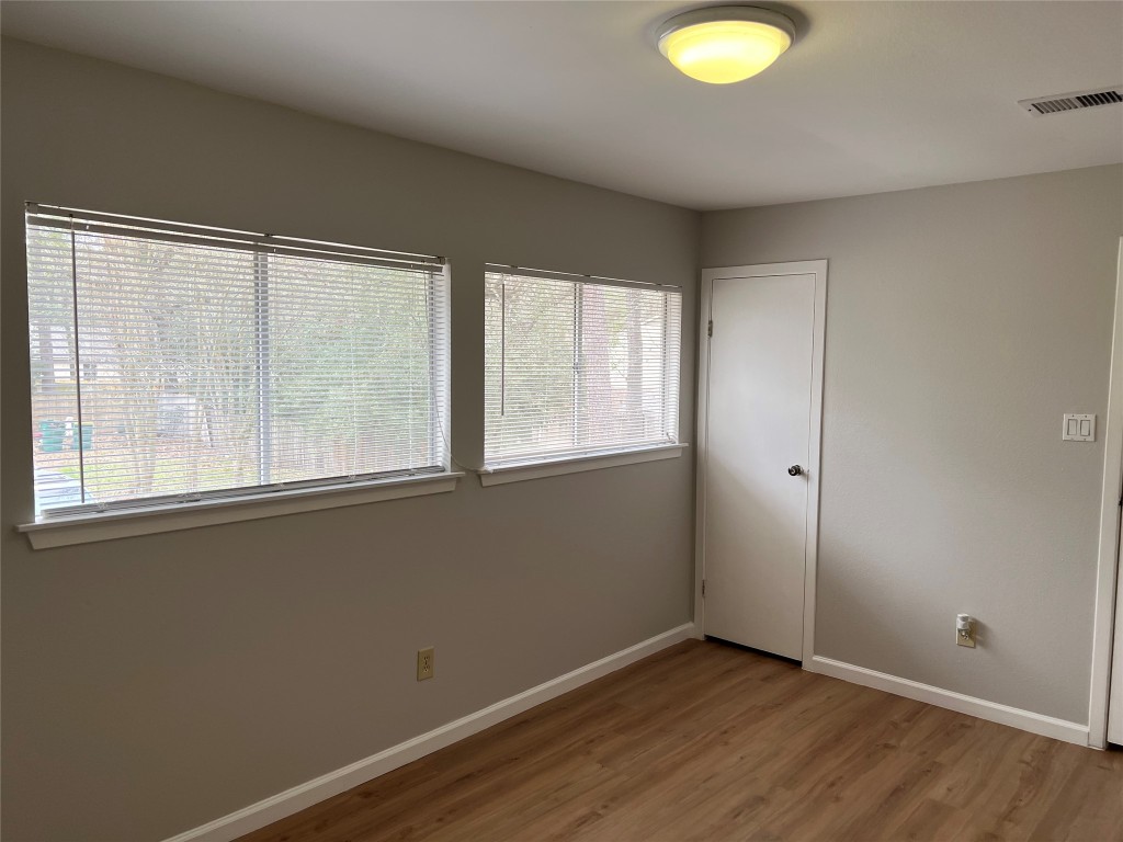 65 Yewleaf Road The Woodlands, TX 77381 - Photo 16 of 21 an empty room with wooden floor and windows