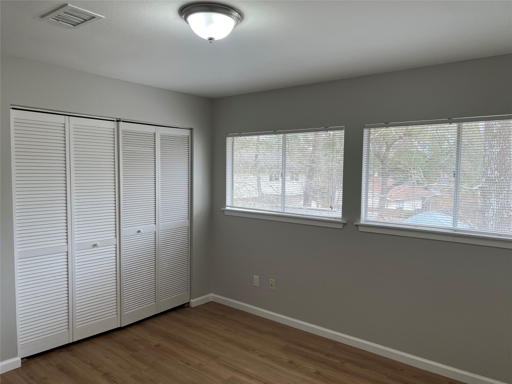 65 Yewleaf Road The Woodlands, TX 77381 - Photo 18 of 21 an empty room with wooden floor and windows