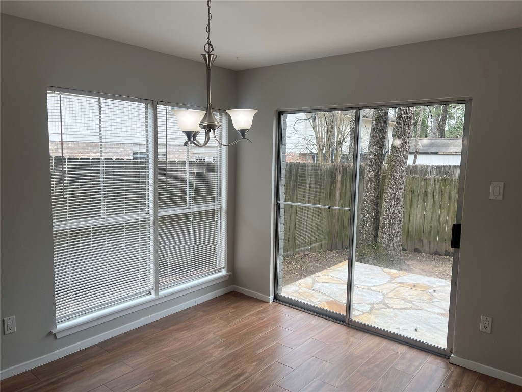 65 Yewleaf Road The Woodlands, TX 77381 - Photo 5 of 21 a view of an empty room and window with wooden floor