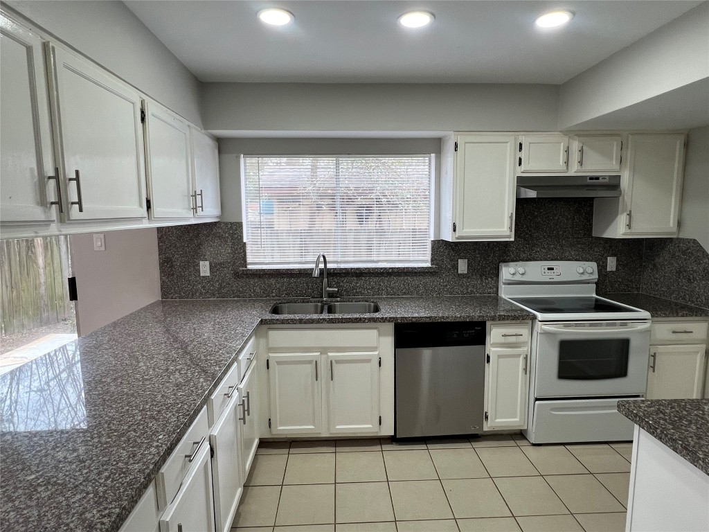 65 Yewleaf Road The Woodlands, TX 77381 - Photo 6 of 21 a kitchen with stainless steel appliances granite countertop a sink stove and cabinets