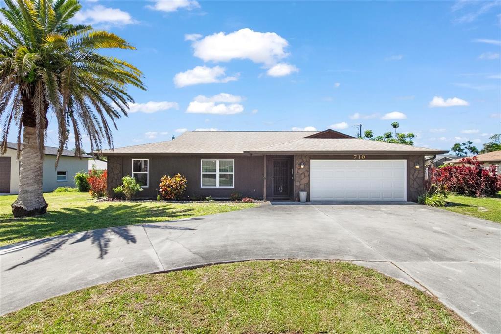 front view of house with a yard and potted plants