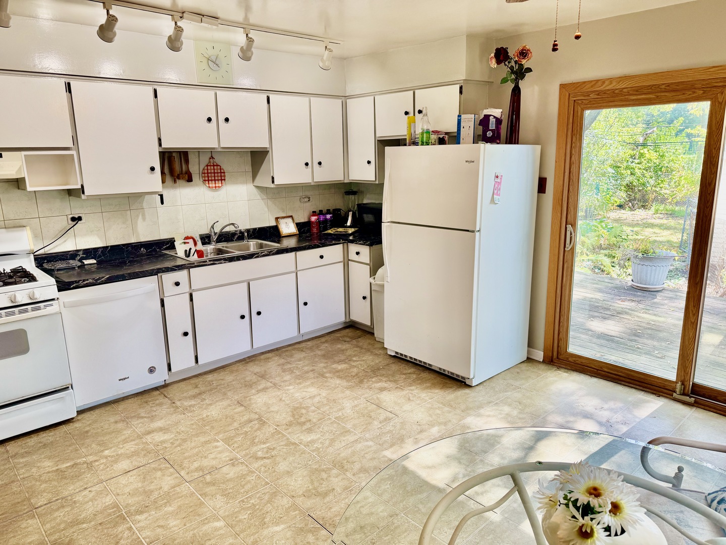 597 Lowden Avenue Glen Ellyn, IL 60137 - Photo 5 of 15 a kitchen with granite countertop a refrigerator a sink and white cabinets