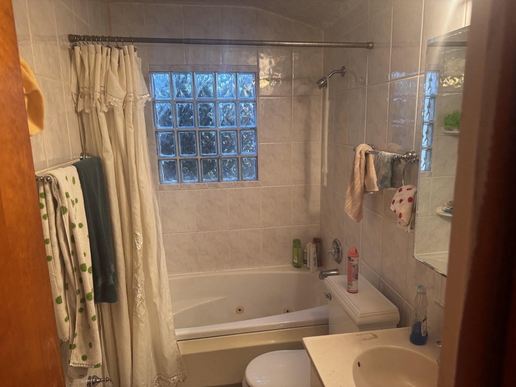 597 Lowden Avenue Glen Ellyn, IL 60137 - Photo 10 of 15 a bathroom with a shower curtain and a bathtub