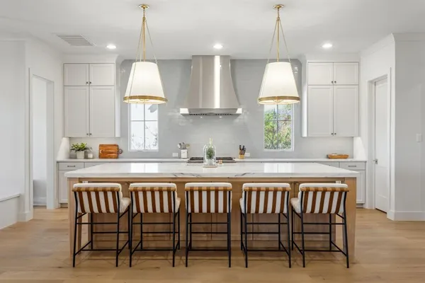 a kitchen with stainless steel appliances granite countertop a stove a sink and a wooden floors