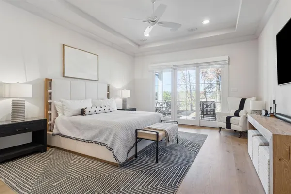 a spacious bedroom with a bed a couch and a flat screen tv