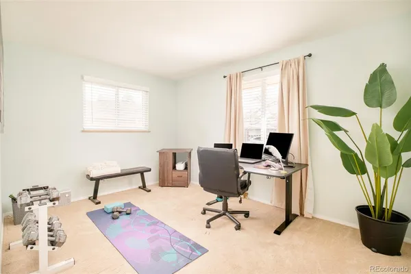 a view of a workspace with furniture and a window