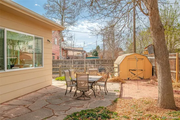 a view of a chairs and table in backyard of the house