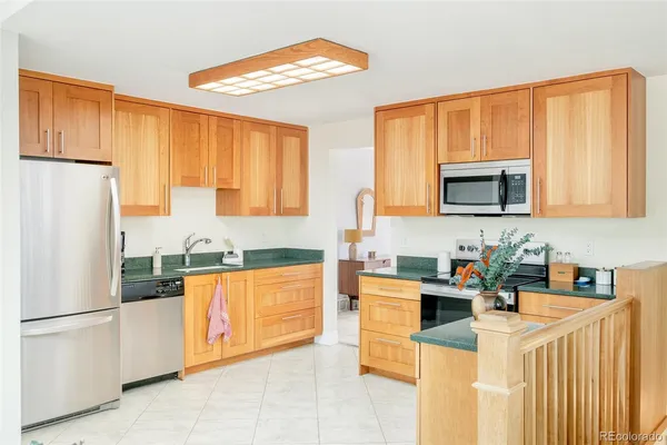 a kitchen with stainless steel appliances granite countertop a refrigerator a stove top oven a sink dishwasher and white appliances