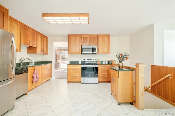 a large kitchen with stainless steel appliances granite countertop a stove and a refrigerator