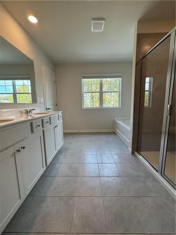 a large white kitchen with a sink window and refrigerator