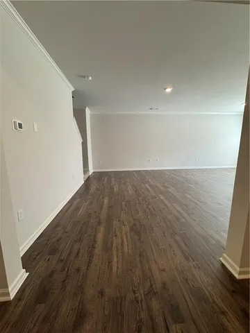 a view of a big room with wooden floor and windows