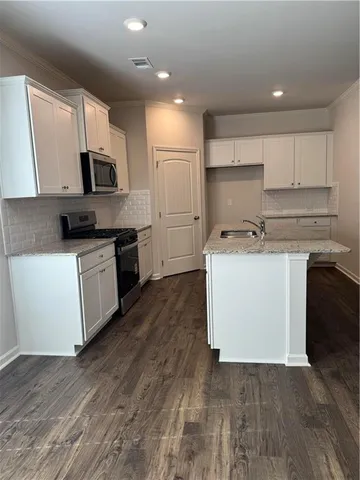 a kitchen with a stove top oven sink and cabinets