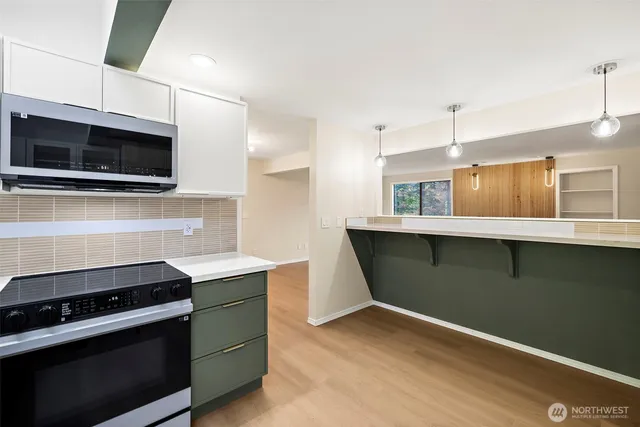 a kitchen with stainless steel appliances a stove microwave and sink