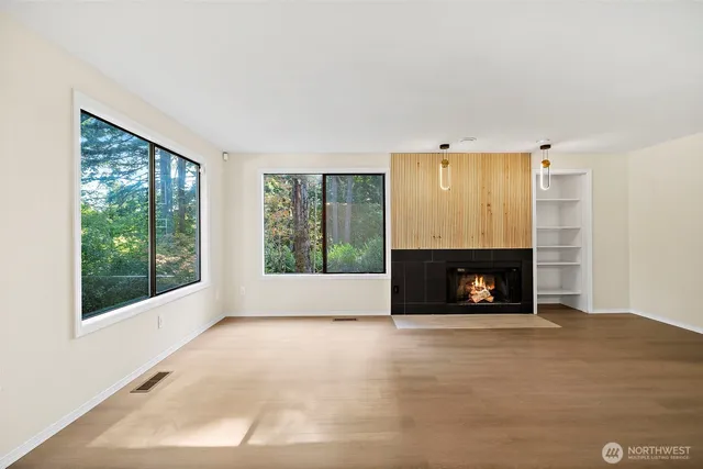 a view of an empty room with a fireplace and a window