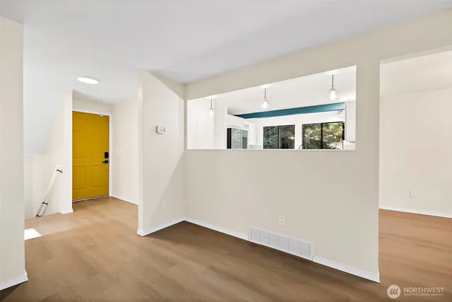 a view of a big room with wooden floor and windows