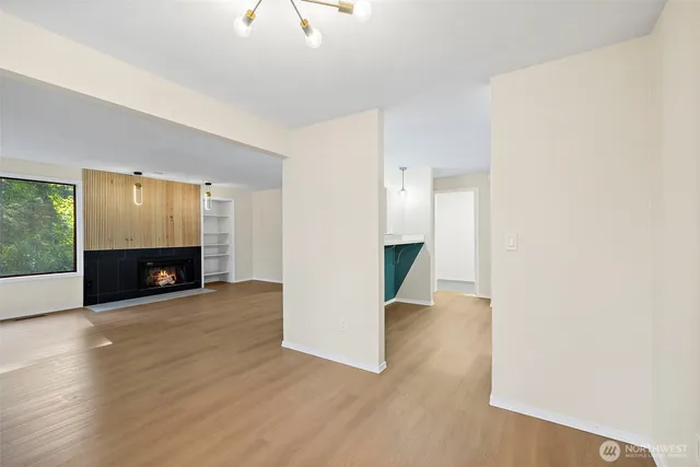 a view of empty room with wooden floor and fireplace