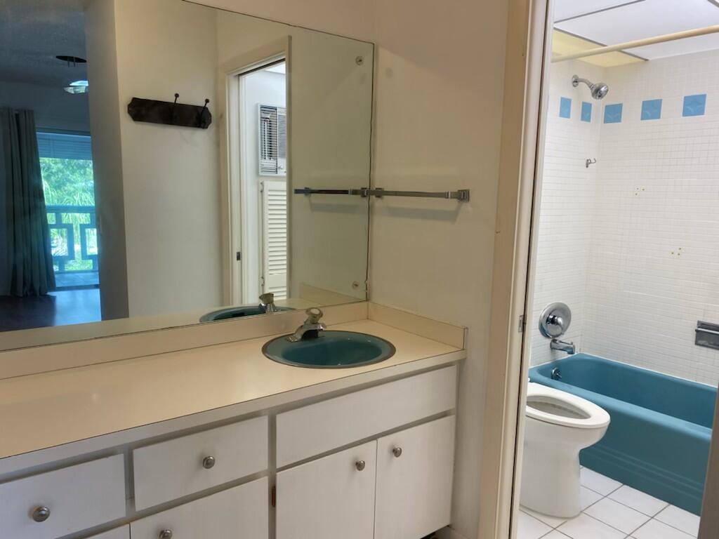 91 Willow Road, Unit 203 Tequesta, FL 33469 - Photo 7 of 9 a bathroom with a granite countertop sink toilet and shower