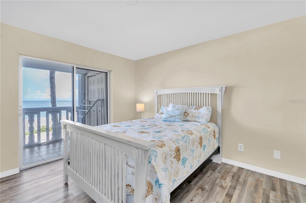403 Gulf Way, Unit 302 St. Pete Beach, FL 33706 - Photo 11 of 30 a bedroom with a bed and wooden floor