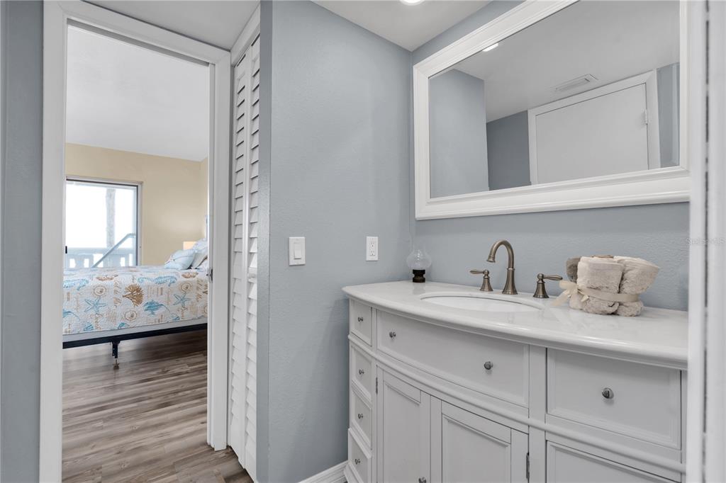 403 Gulf Way, Unit 302 St. Pete Beach, FL 33706 - Photo 14 of 30 a en suite bathroom with a granite countertop sink and a mirror