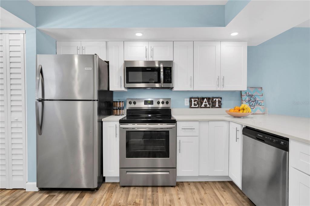 403 Gulf Way, Unit 302 St. Pete Beach, FL 33706 - Photo 8 of 30 a kitchen with stainless steel appliances a refrigerator stove and microwave