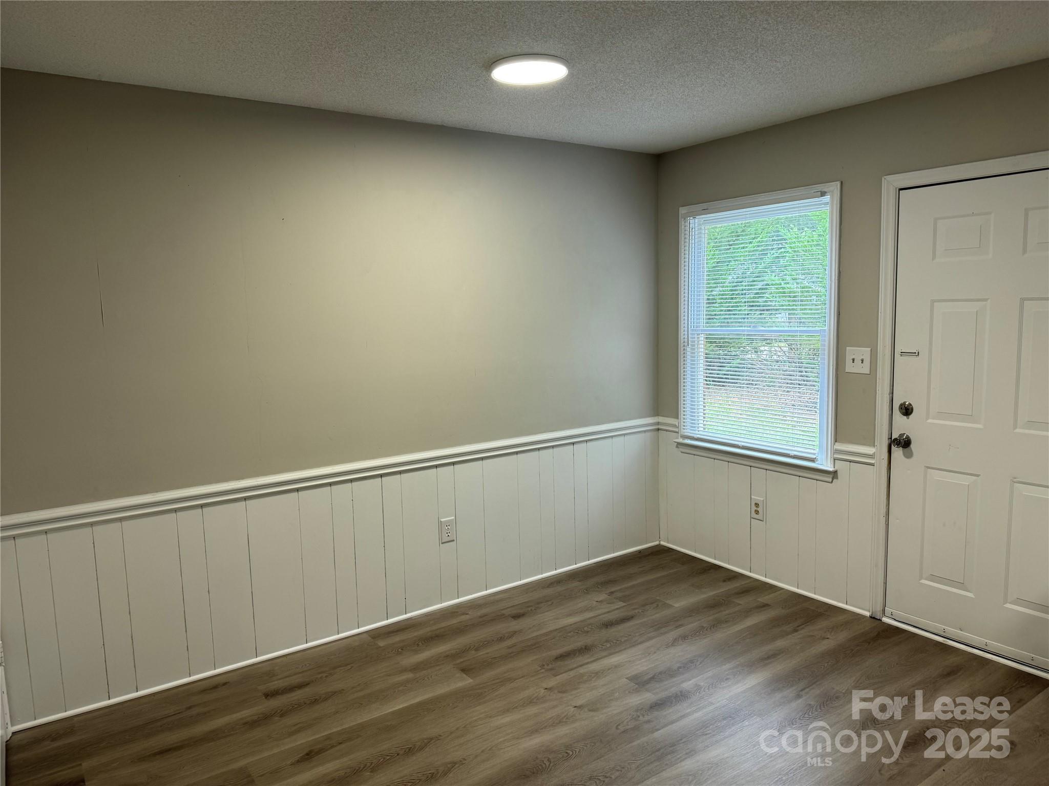 296 Hamilton Drive Northeast, Unit 9 Concord, NC 28025 - Photo 5 of 10 an empty room with wooden floor and window