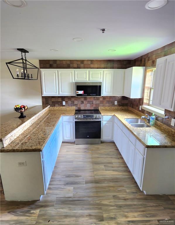 1500 Humming Bird Court, Unit 22 Pharr, TX 78577 - Photo 5 of 15 a large kitchen with granite countertop a stove and a sink