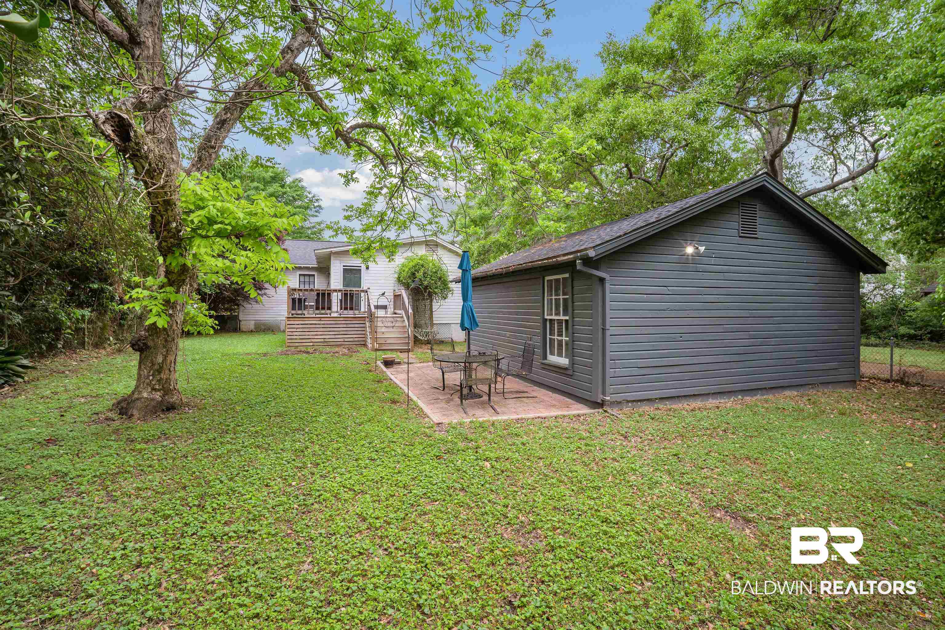 103 Emogene Place Mobile, AL 36606 - Photo 30 of 32 Rear view of house featuring a wooden deck, a patio, and an outdoor structure